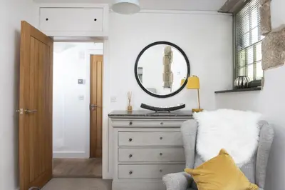 a bedroom with a dresser and a mirror at Fairings, St Ives in St Ives