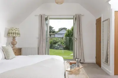 a bedroom with a bed and a large window at Fairings, St Ives in St Ives