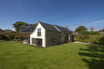 a white house with a grass yard at Fairings, St Ives in St Ives