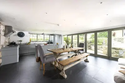 a kitchen and dining room with a wooden table and chairs at Fairings, St Ives in St Ives