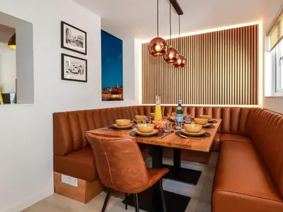 a dining room with a table and leather chairs at Sea Candy in St Ives