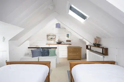 two beds in a attic room with white walls at No 1 St Eia, St Ives in St Ives