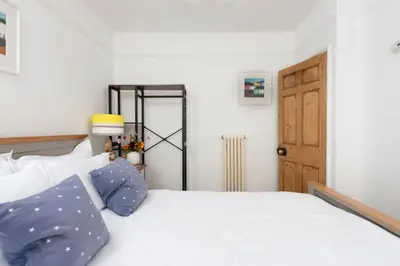 a bedroom with a white bed with blue pillows at No 1 St Eia, St Ives in St Ives