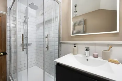 a bathroom with a sink and a glass shower at No 1 St Eia, St Ives in St Ives