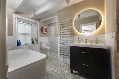 a bathroom with a tub and a sink and a mirror at No 1 St Eia, St Ives in St Ives