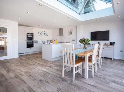 a kitchen and dining room with a table and chairs at Padstow Escapes - Trenemere in Padstow
