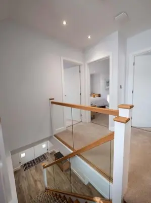 a room with a staircase with a bed in the background at Padstow Escapes - Trenemere in Padstow