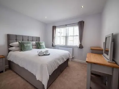 a bedroom with a large bed and a television at Padstow Escapes - Trenemere in Padstow