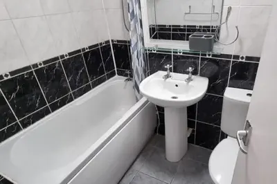 a black and white bathroom with a sink and a toilet at 2 Bed Cottage Sleeps 5 - Pets Allowed in Newquay