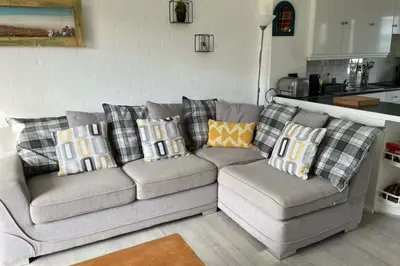 a living room with a couch with pillows on it at 2 Bed Cottage Sleeps 5 - Pets Allowed in Newquay