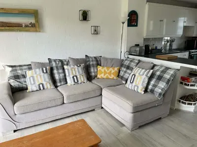 a living room with a couch with pillows on it at 2 Bed Cottage Sleeps 5 - Pets Allowed in Newquay