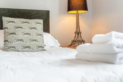 a bed with a pile of towels and the eiffel tower at 4 Bed in Newquay oc-b29882 in Newquay