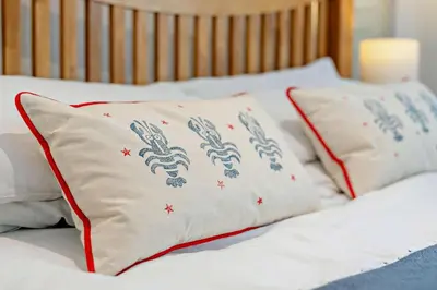two white pillows with red trim on a bed at 5 Bed in Padstow oc-s29853 in Padstow