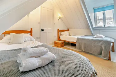 a attic bedroom with two beds and a window at 5 Bed in Padstow oc-s29853 in Padstow