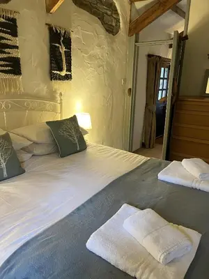 a bedroom with a large bed with towels on it at Cobble by Together Travel - Luxury Cornish Countryside Retreat in Bodmin