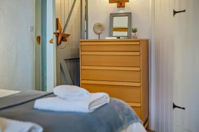 a bedroom with a bed with a dresser and a mirror at Cobble by Together Travel - Luxury Cornish Countryside Retreat in Bodmin