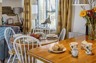 a dining room table and chairs with a table and a dining room at Cobble by Together Travel - Luxury Cornish Countryside Retreat in Bodmin