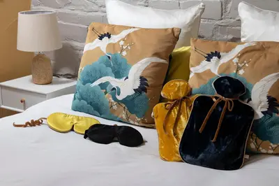 a bed with a bunch of pillows on it at Zen Den Cornwall in Boscastle