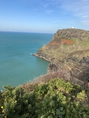 a lighthouse on top of a cliff next to the ocean at Zen Den Cornwall in Boscastle