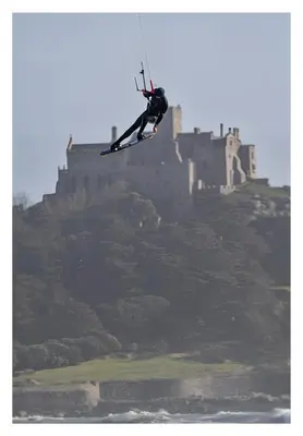 a person on skis jumping in front of a castle at Beach House Apartment, Across St Michaels Mount in Marazion