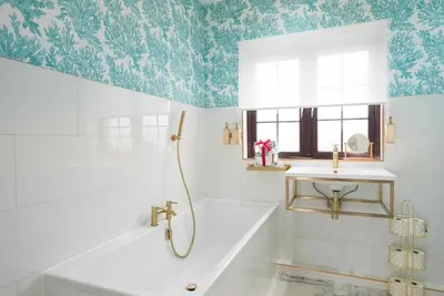 a bathroom with a tub and a sink at Beach House Apartment, Across St Michaels Mount in Marazion