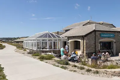 a group of people sitting outside of a building at Beach House Apartment, Across St Michaels Mount in Marazion