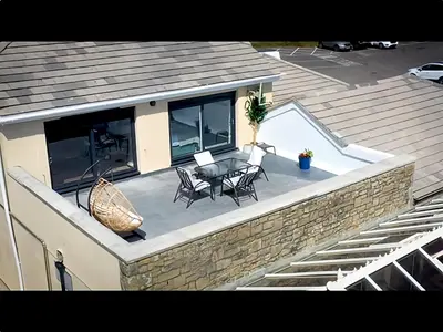 a patio with a table and chairs on top of a house at Beach House Apartment, Across St Michaels Mount in Marazion