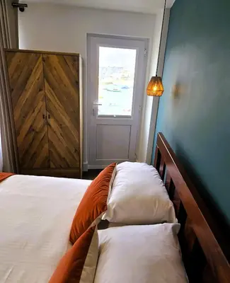 a bedroom with a bed with two pillows and a window at Premier 4 - Stunning Suite, beautiful sea views in St Ives