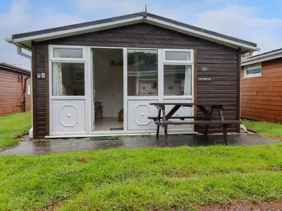 a small shed with a picnic table in front of it at Constantine Bay in Padstow