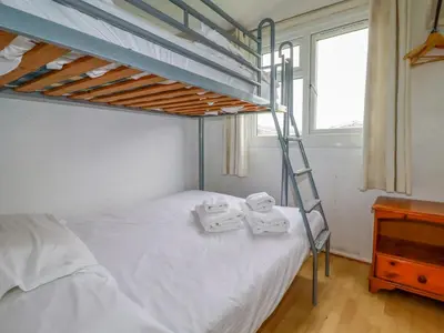 a bedroom with a bunk bed with two towels on it at Constantine Bay in Padstow