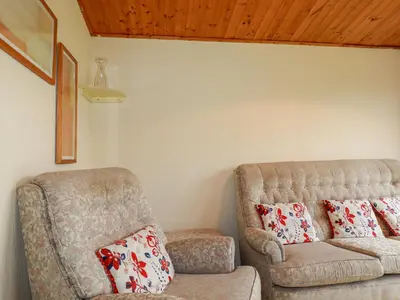 a living room with a couch and a chair at Newtrain Bay in Padstow