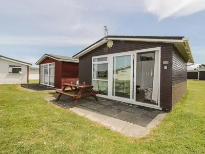 a small house with a picnic table in the yard at Warren Cove in Padstow