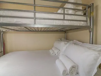 a bunk bed with white pillows and towels at Warren Cove in Padstow
