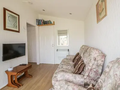 a living room with a couch and a tv at Warren Cove in Padstow