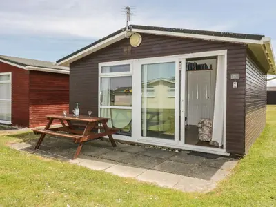 a small shed with a picnic table and a table at Warren Cove in Padstow