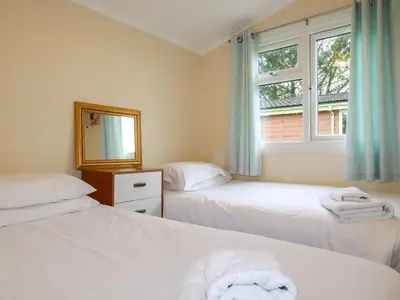 a bedroom with two beds and a mirror and a window at Hawker's Cove in Padstow