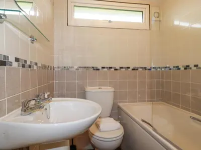 a bathroom with a sink and a toilet and a tub at Hawker's Cove in Padstow
