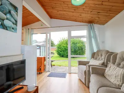 a living room with couches and a sliding glass door at Hawker's Cove in Padstow