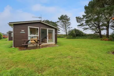 a small shed with a table in a grass field at High Cove in Padstow