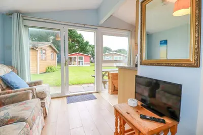a living room with a couch and a tv and a mirror at High Cove in Padstow