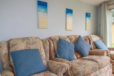 a living room with a couch with blue pillows at High Cove in Padstow