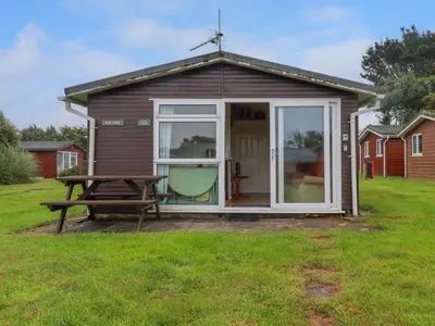 a small shed with a picnic table and a bench at Fox Cove in Padstow