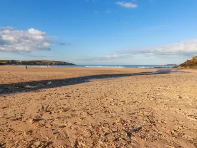 a sandy beach with a stream of water at Fox Cove in Padstow