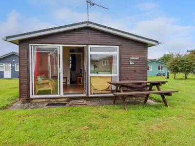 a tiny house with a picnic table in front of it at Pepper Cove in Padstow