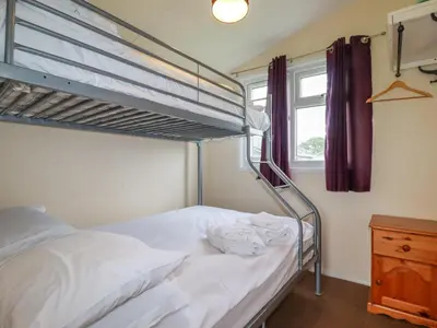 a bedroom with a bunk bed and a window at Pepper Cove in Padstow