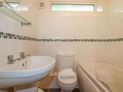 a bathroom with a sink and a toilet and a tub at Pepper Cove in Padstow
