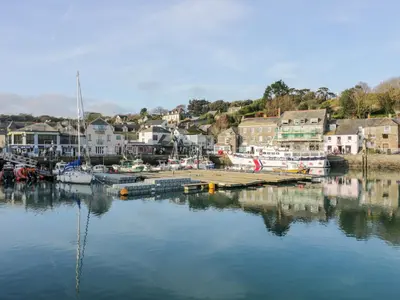 a river with boats docked in a town with houses at Pepper Cove in Padstow
