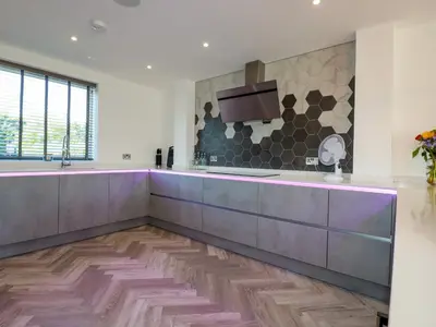 a kitchen with a large counter and a tv on the wall at Carnon Gwel, Devoran in Truro