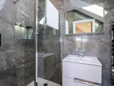 a bathroom with a shower and a sink and a mirror at Carnon Gwel, Devoran in Truro