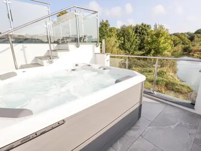 a jacuzzi tub on a balcony with a view at Carnon Gwel, Devoran in Truro